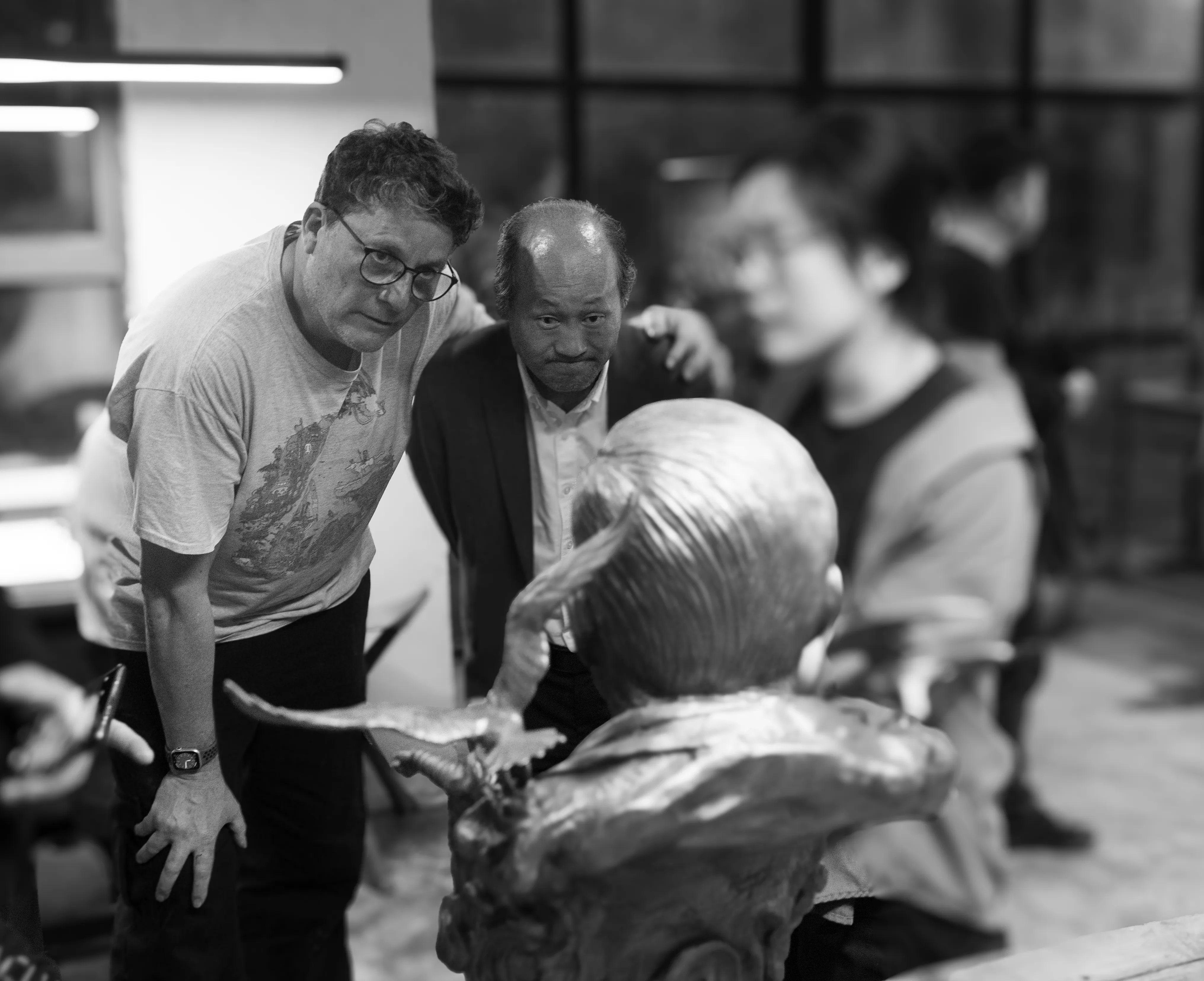 Visitors and Xinjiuding team members discussing models during a creative exchange.