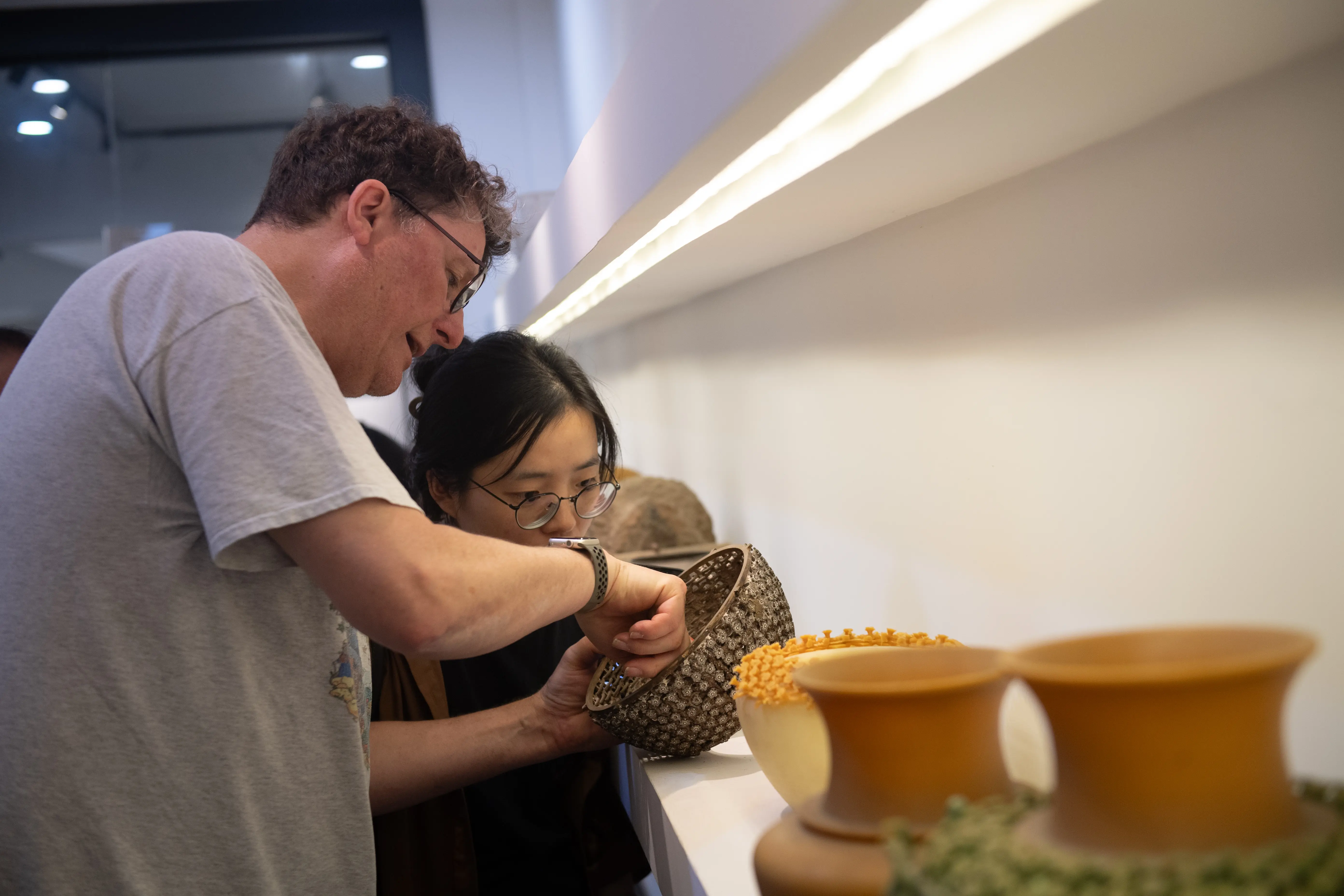 Visitors examining traditional lost-wax casting displays.