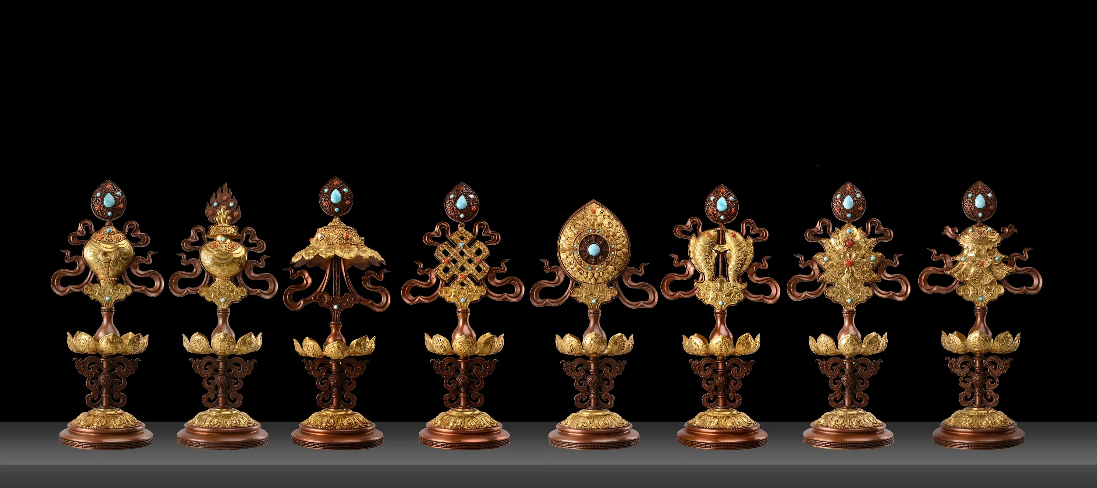 Set of eight gilded copper Buddhist emblems with gemstone inlay representing the Eight Auspicious Symbols