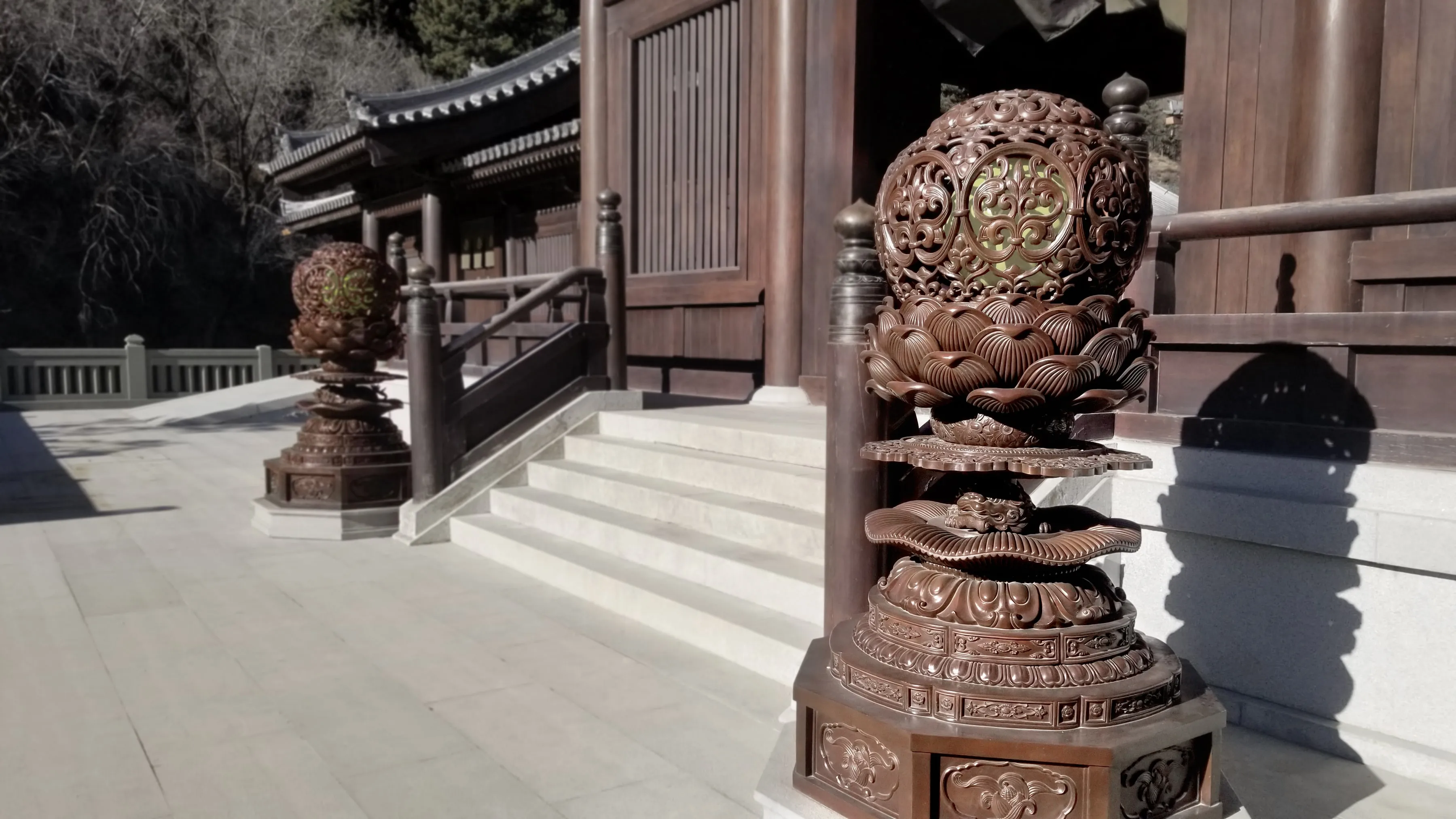 Pair of monumental bronze offering lamps installed beside the entrance of a Buddhist temple at Mount Wutai