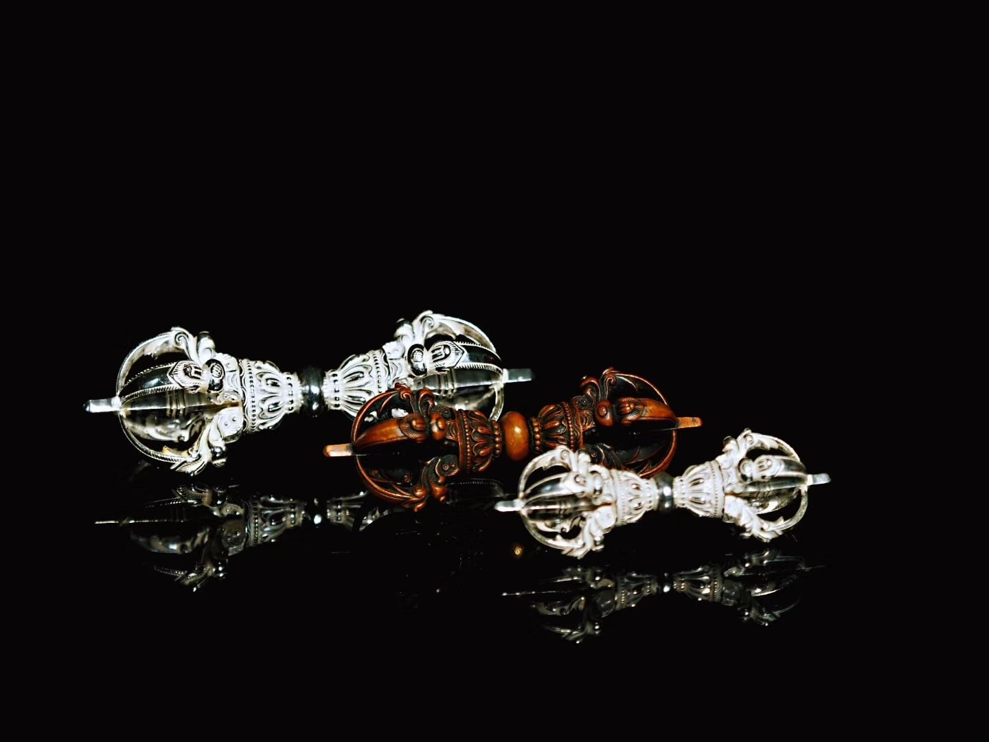 Small bronze and silver vajras featuring symmetrical openwork forms and finely detailed components