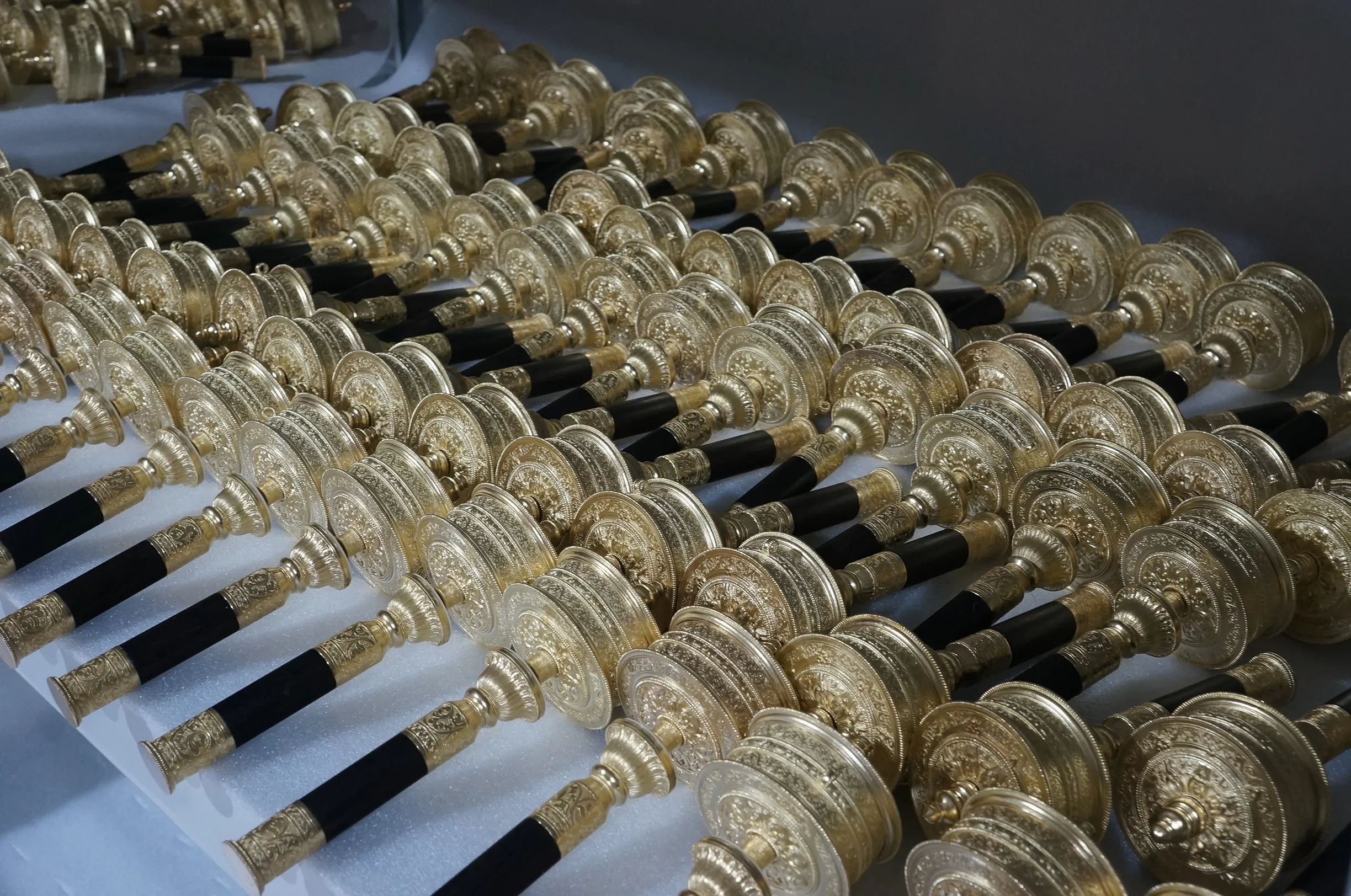 A large production batch of finished precision-cast decorative components arranged for inspection.