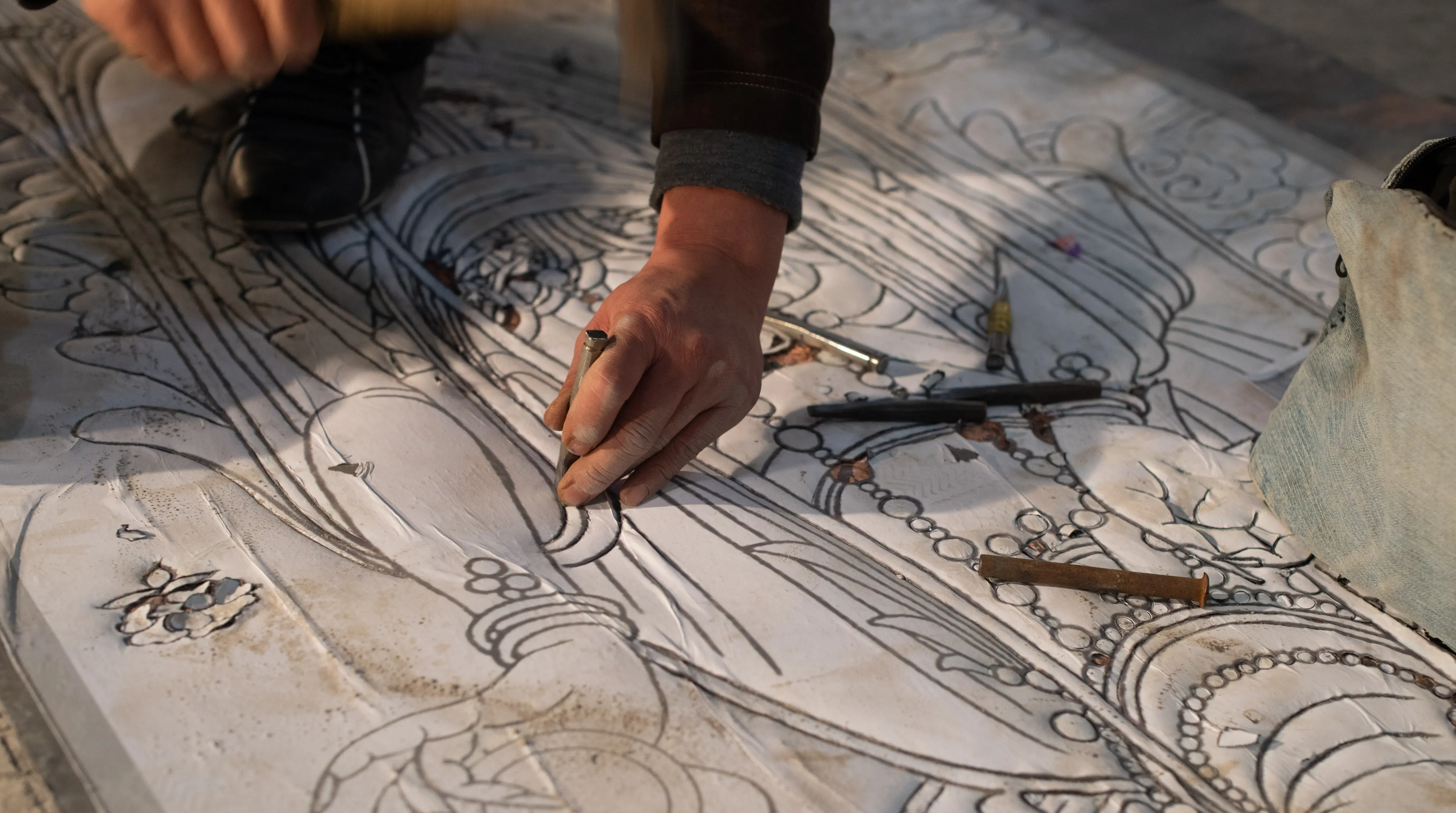 Artisans forming and fabricating a large metal sculpture in the workshop.