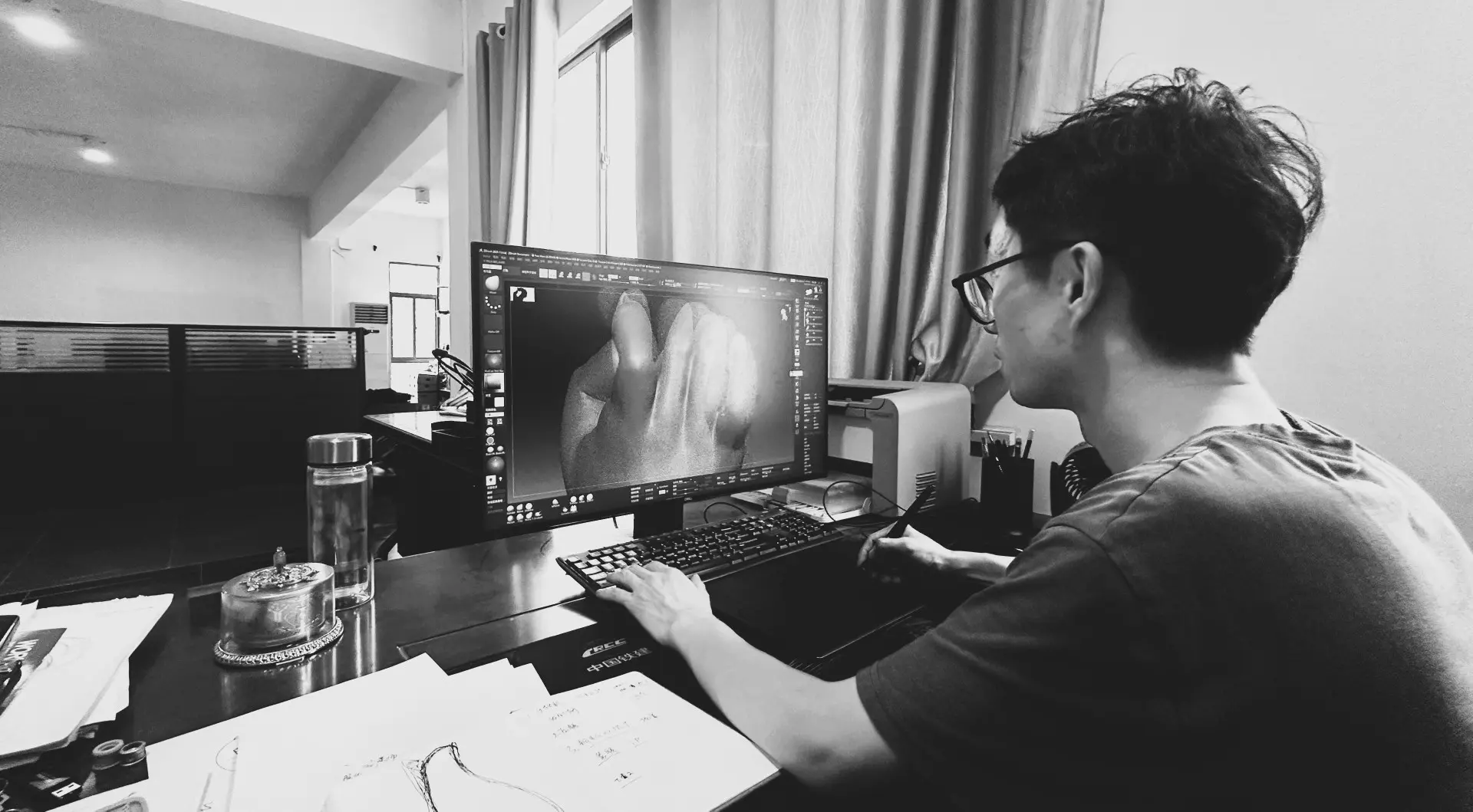 A designer refining a sculptural model at a digital workstation.