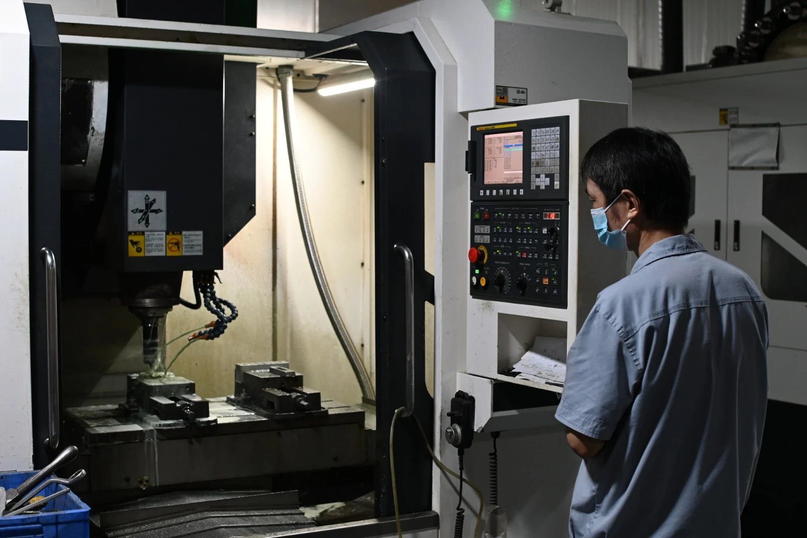 Operator monitoring a CNC machine during metal mould production