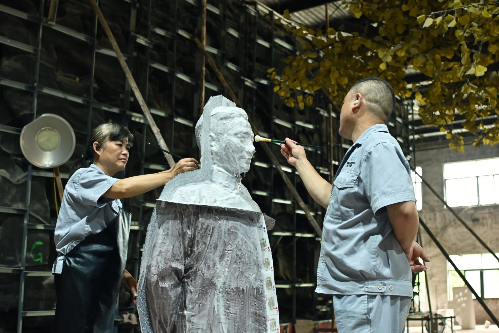 Craftspeople applying silicone to a sculptural model