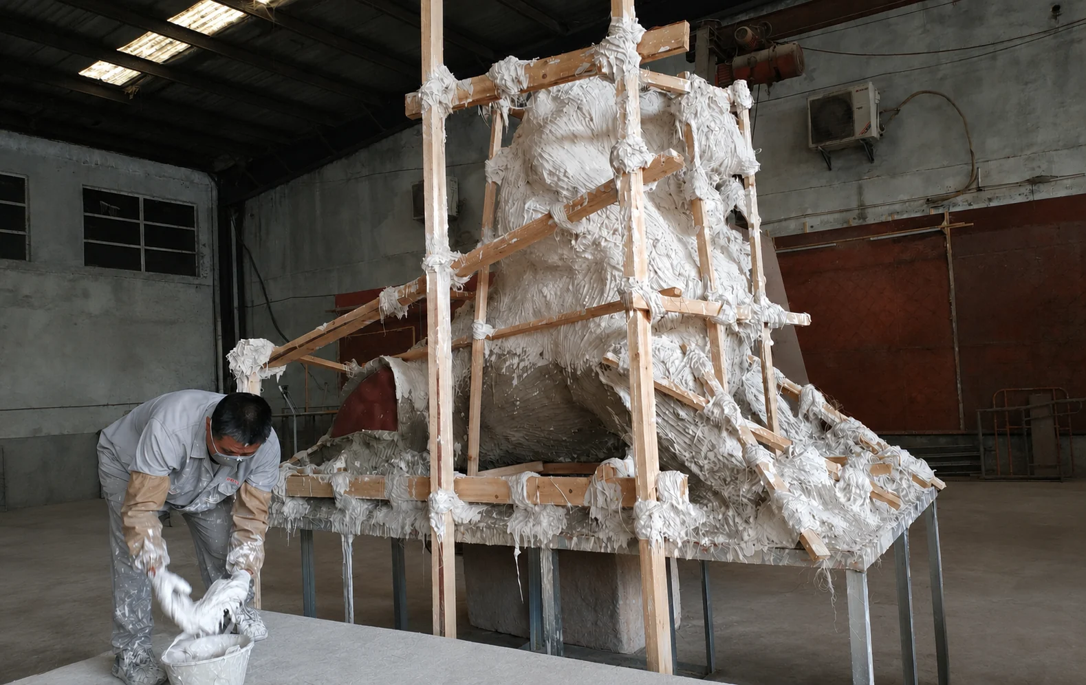 Craftsperson working on the reverse side of a reinforced plaster mould