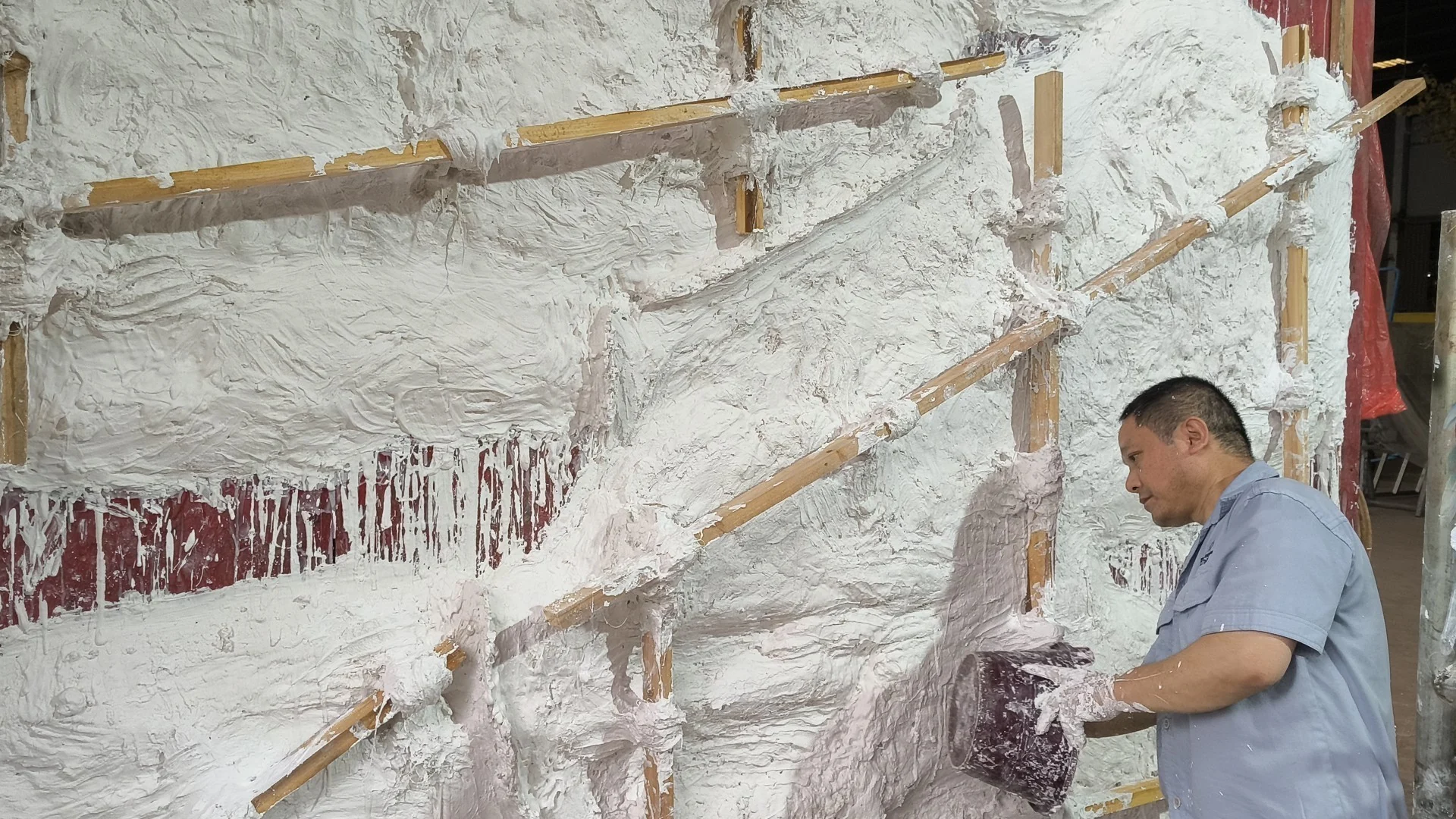 Craftsperson applying plaster to a reinforced mould surface