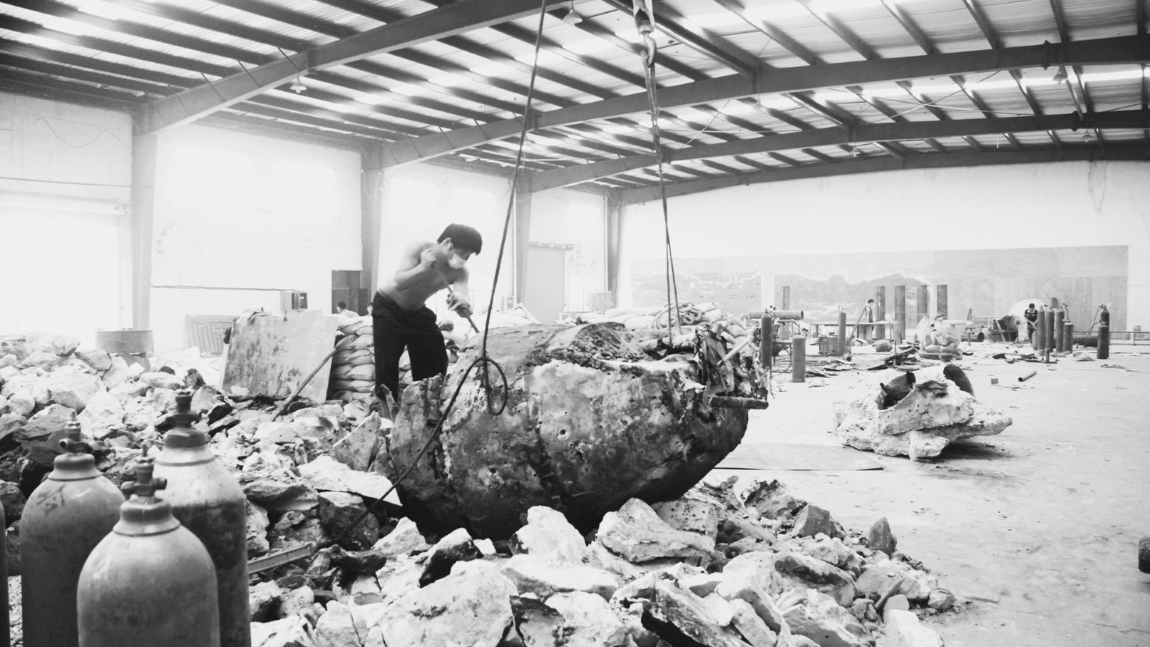 Worker breaks away a large sand mould inside the foundry.