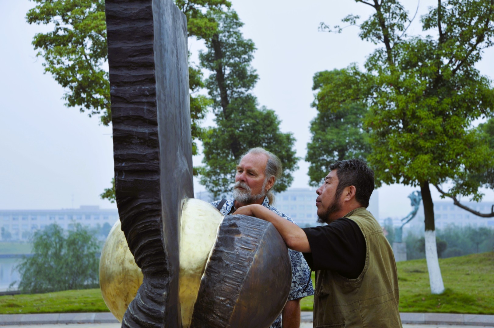 Two people examining an outdoor sculpture together.