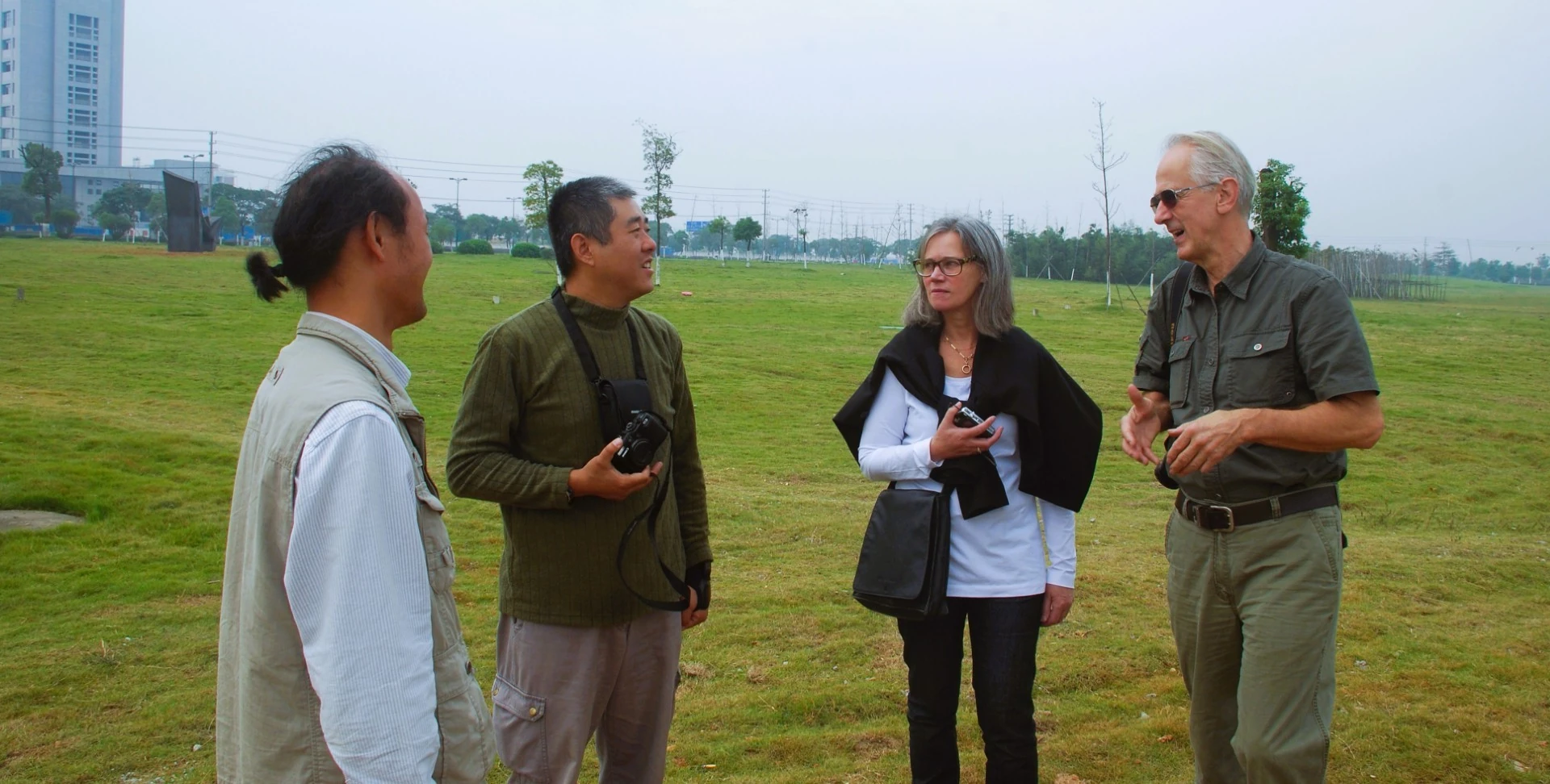 Participants discuss a work in an outdoor sculpture setting.