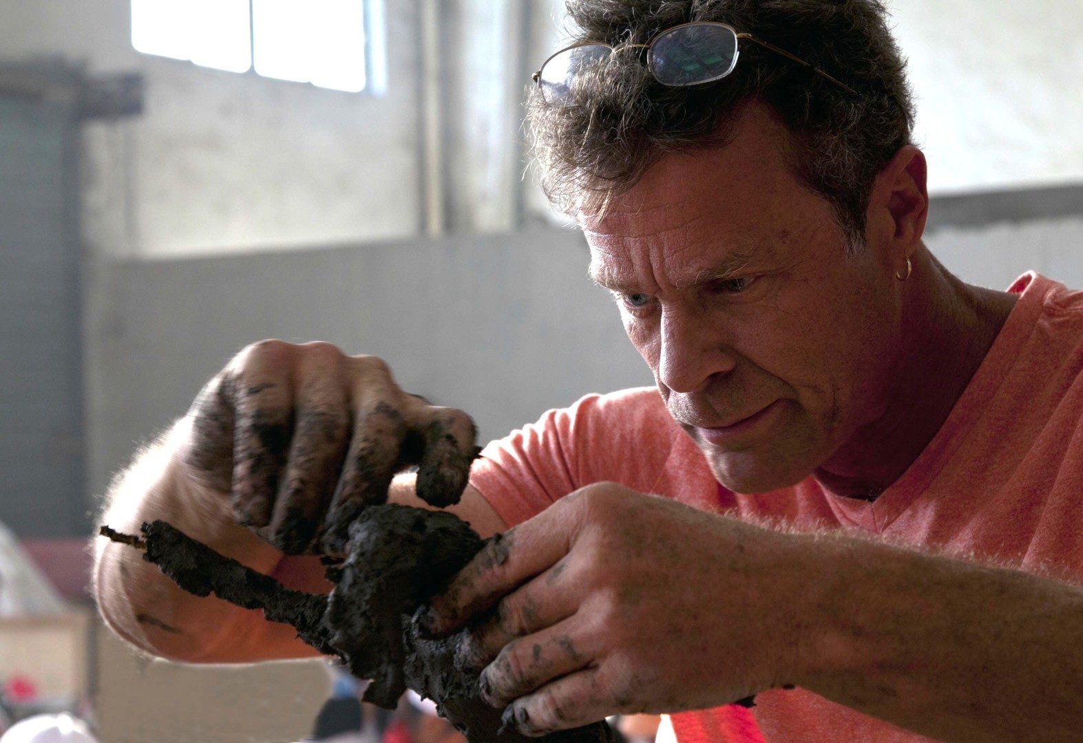 An artist models a small sculptural form by hand.