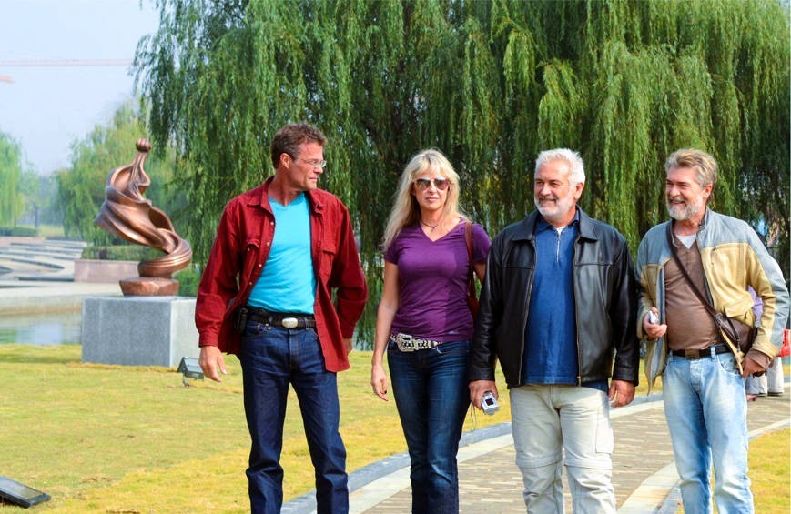 Four participants stand together in the sculpture park.