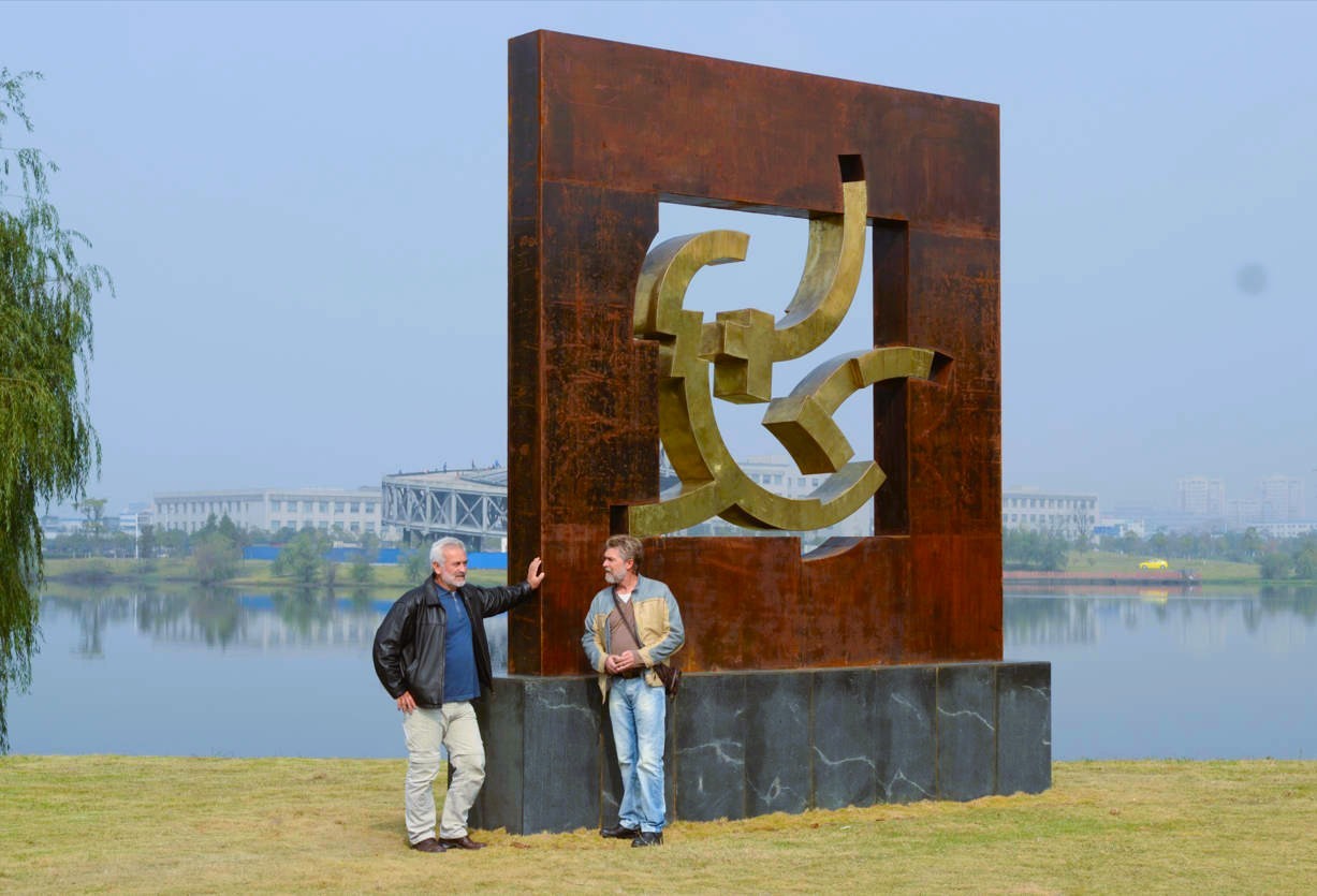 Two participants stand beside a completed framed sculpture.