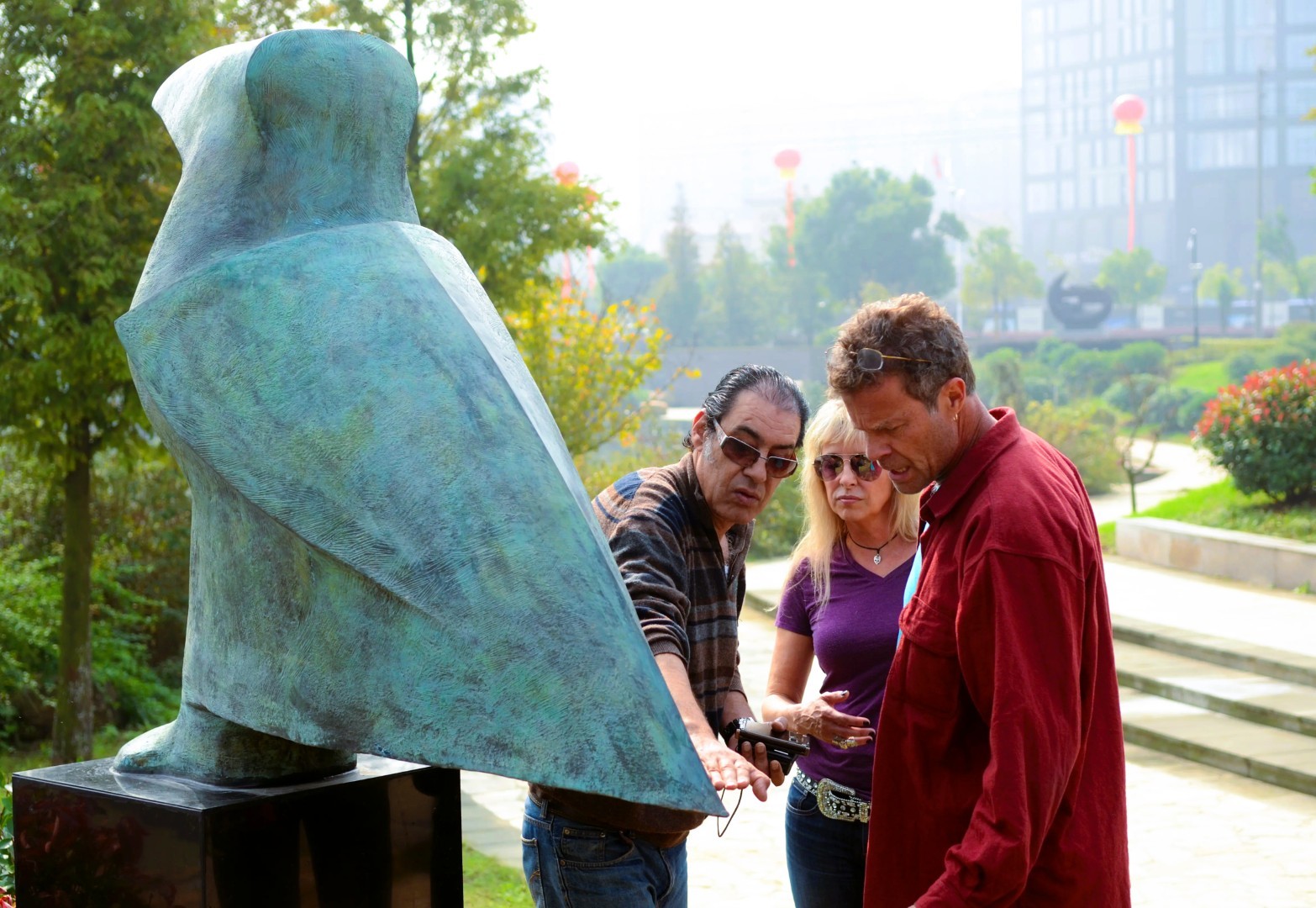 Participants examine a green sculpture at close range.
