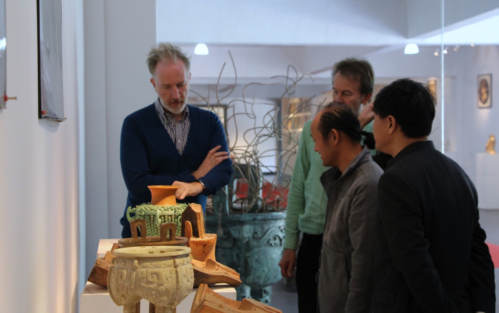 The visiting film crew and Xinjiuding staff gathered beside bronze vessels.