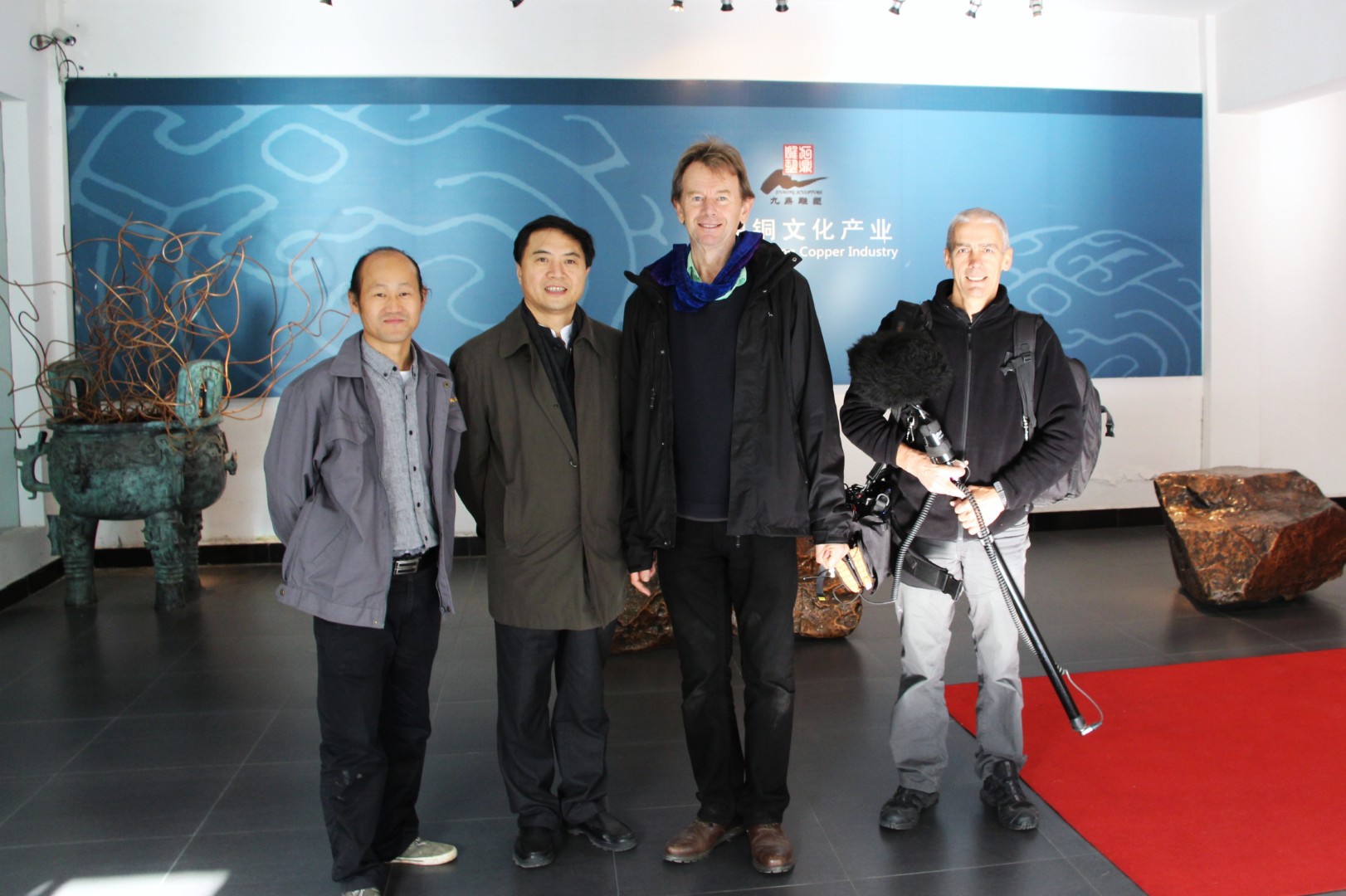 Members of the visiting film crew and Xinjiuding team posing together with filming equipment.