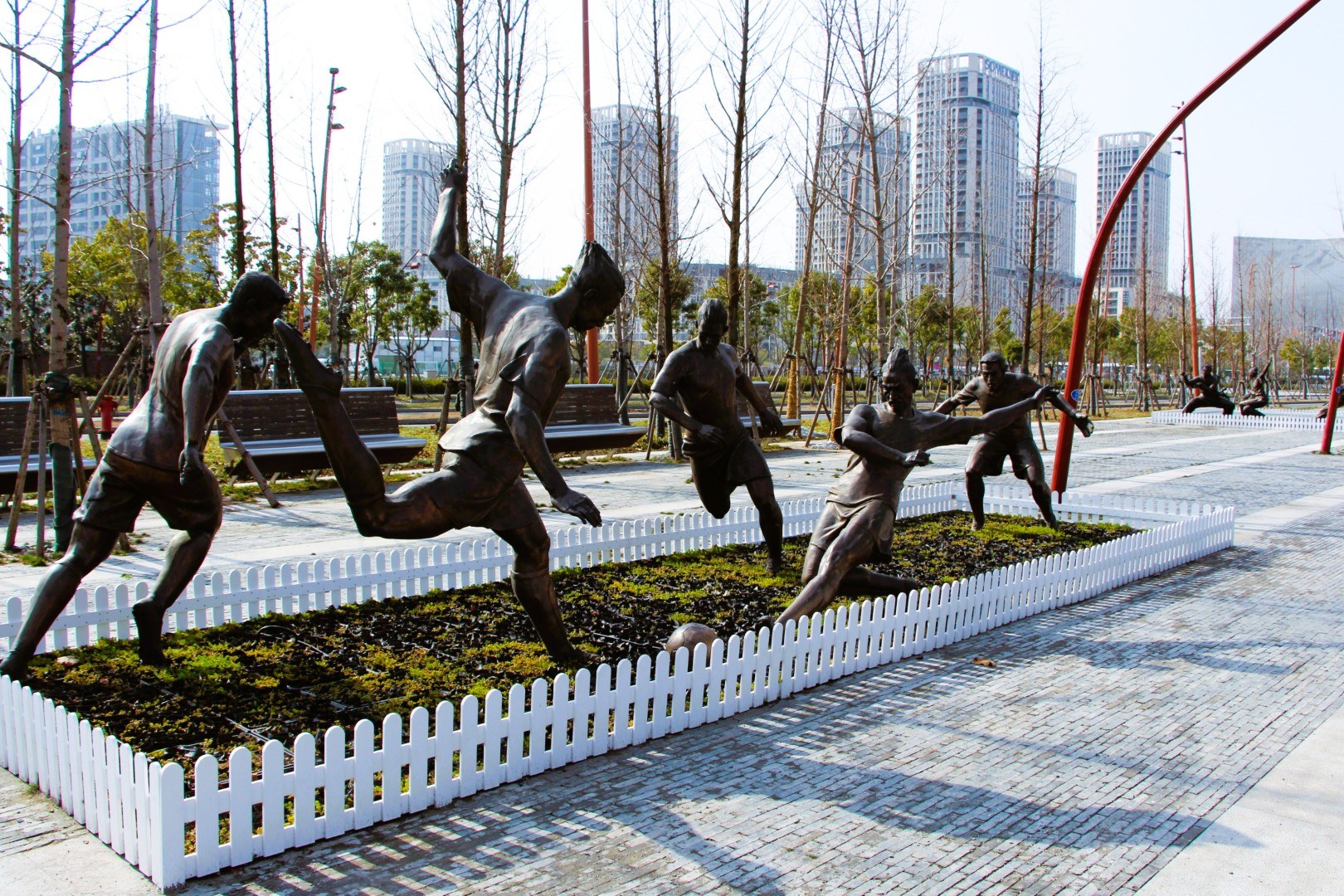 Athlete sculptures in the park landscape.