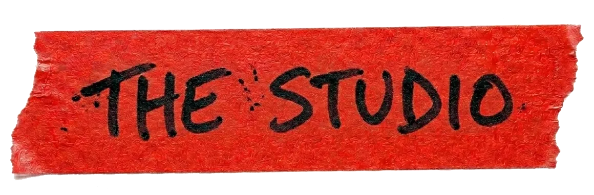 Red textured tape with black handwritten text 'THE STUDIO'.