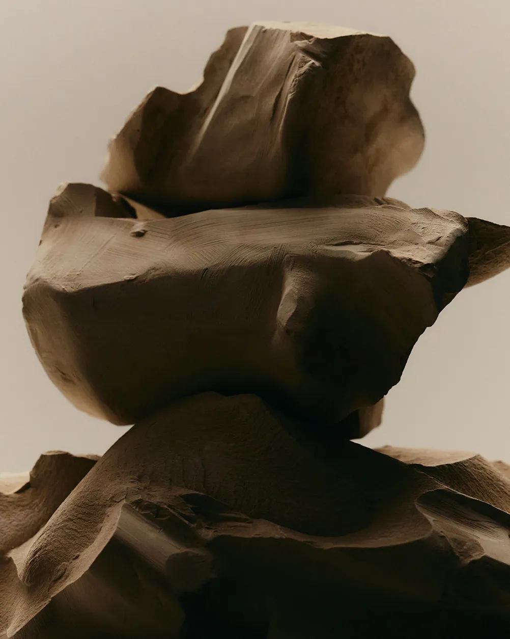 Close-up of layered beige rock formations with smooth and rough textures.