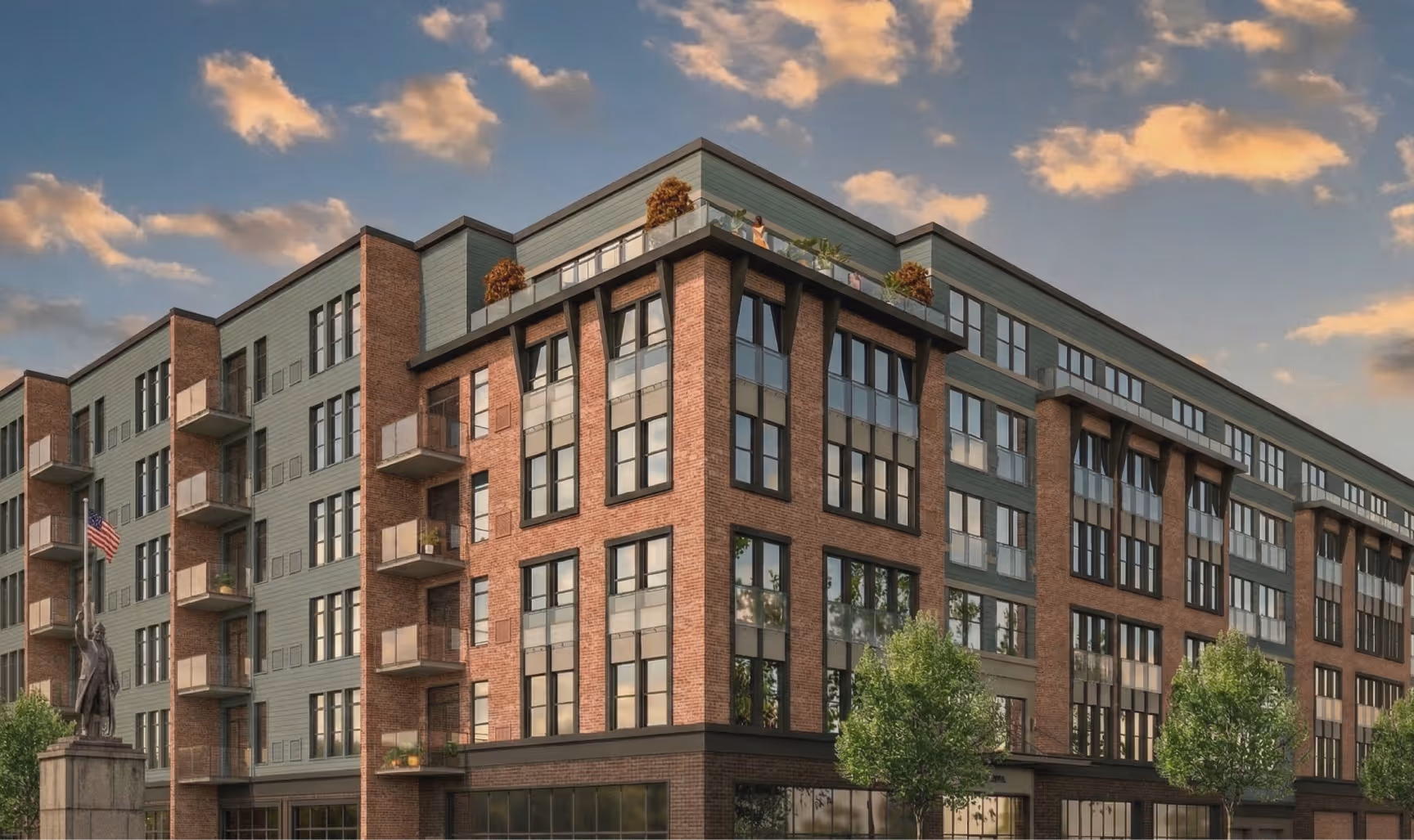 Modern multi-story brick and glass apartment building with balconies and rooftop terrace under a cloudy sky.