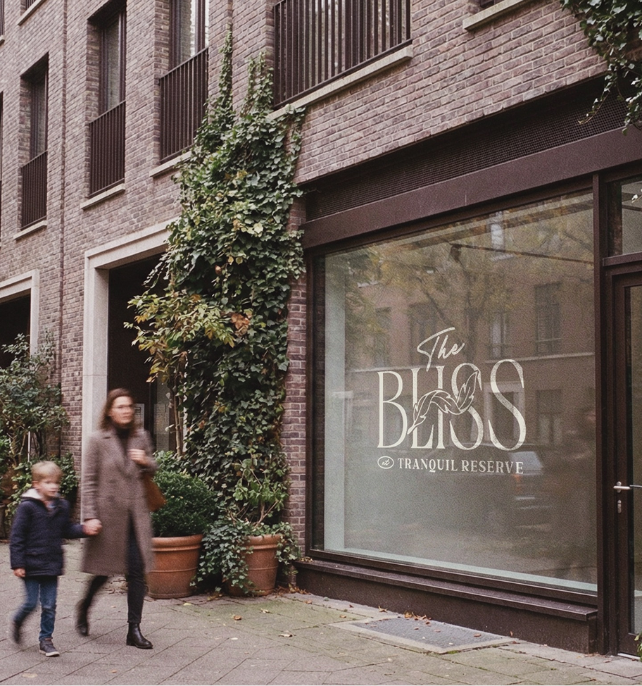 Woman and child walking past a brick building with a sales office window for The Bliss Tranquil Reserve.