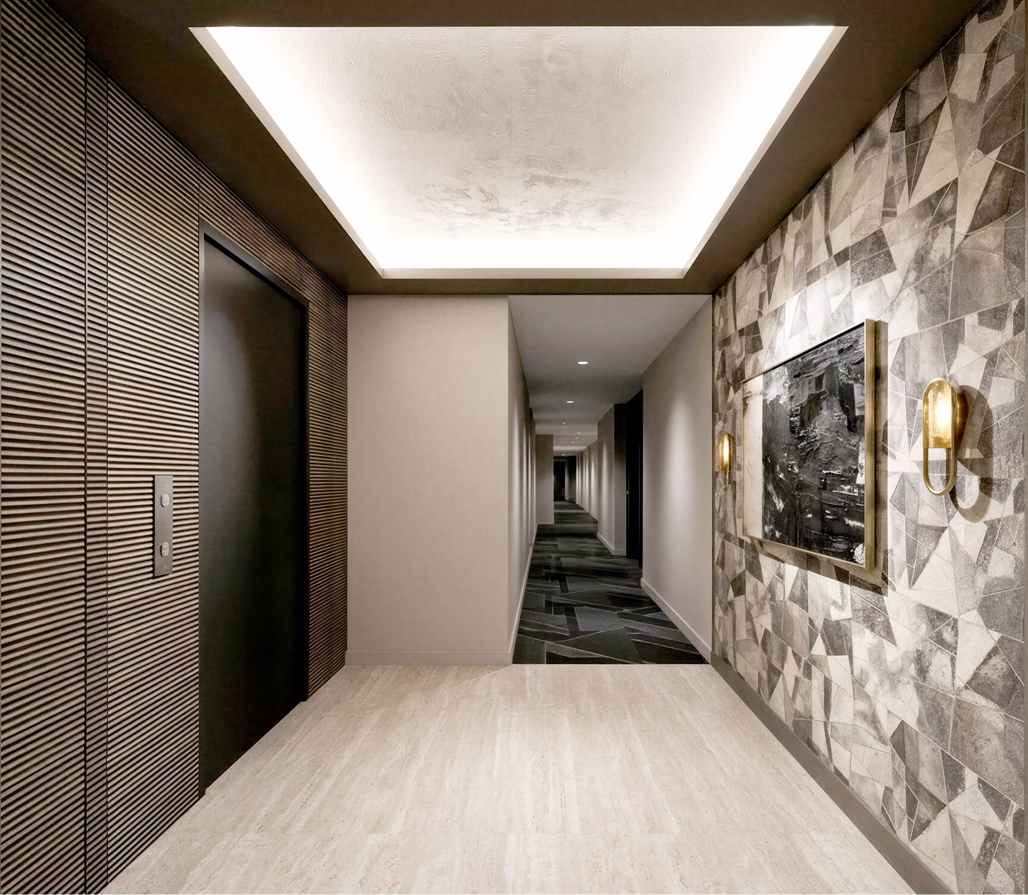 Modern hallway with geometric wall art, recessed ceiling light, elevator door, and patterned carpet.