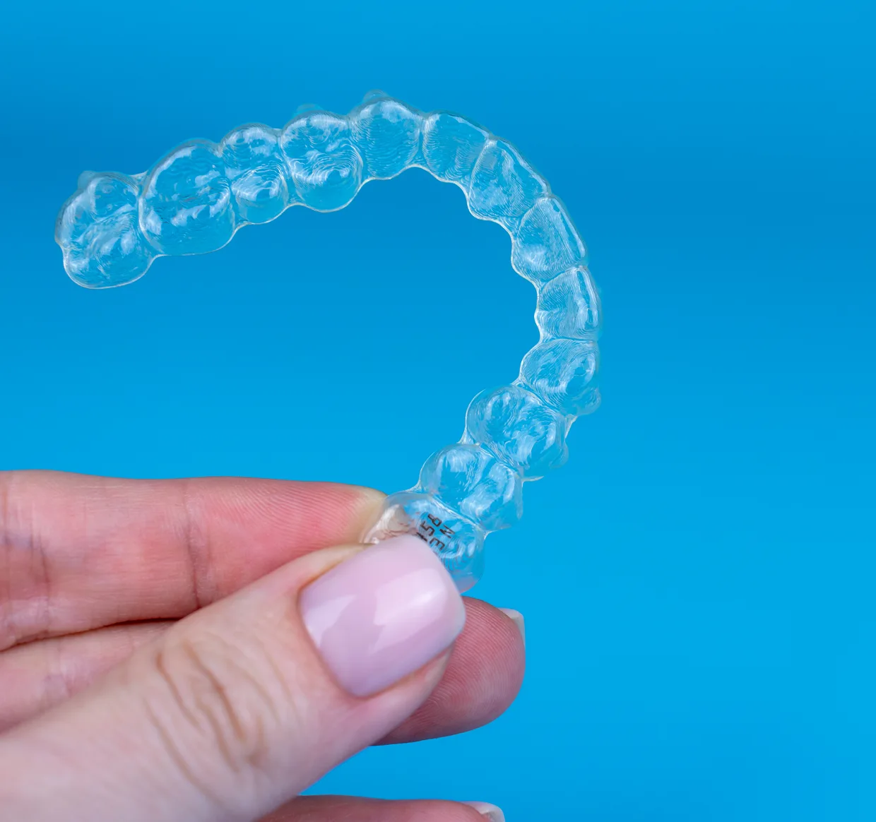 Allineatore dentale trasparente tenuto in mano