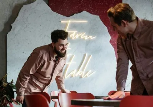 Two waiters working together to clean tables