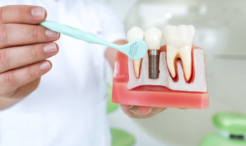 Patient brushing teeth carefully around a healing dental implant at Arvada Dental Center & Implants in Arvada, CO