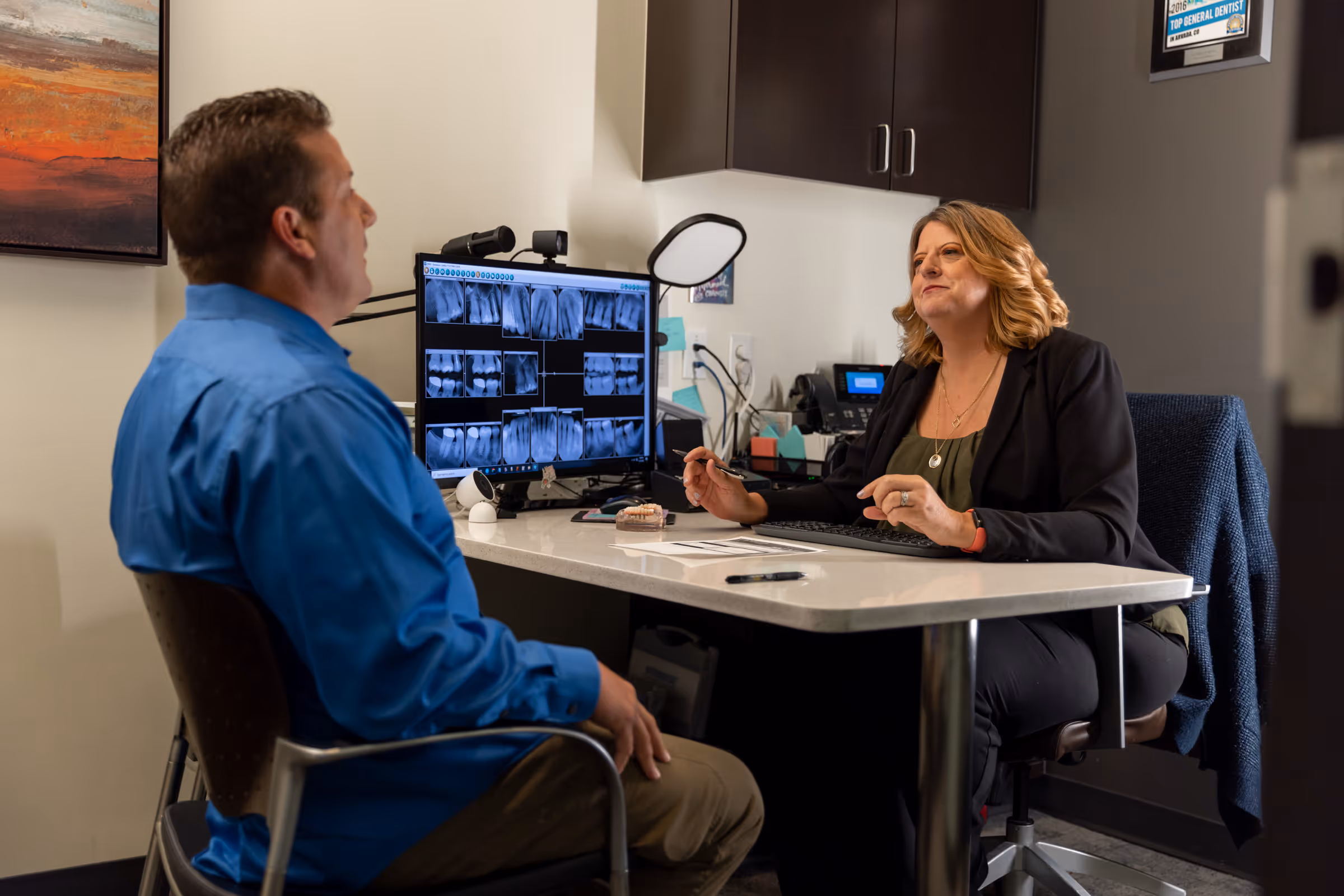 Financial coordinator explaining dental implant financing options to a patient at Arvada Dental Center & Implants in Arvada, CO