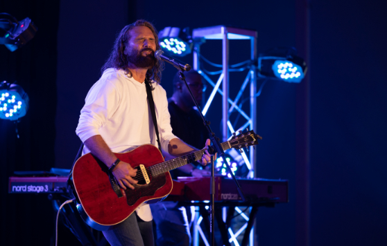 A guy singing with a guitar at Faith Christian Fellowship