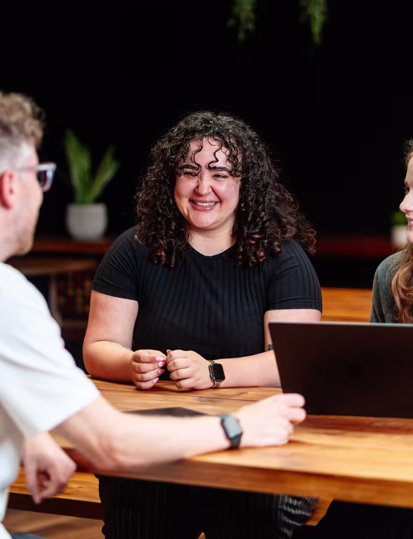 An EGA team member smiling during a meeting with colleagues.