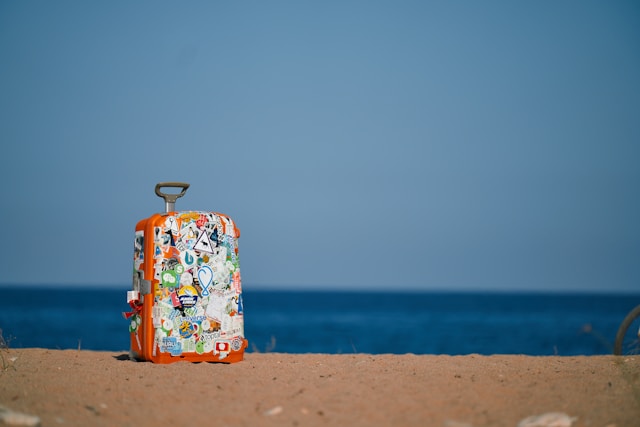 a suitcase on the beach with the sea in the background