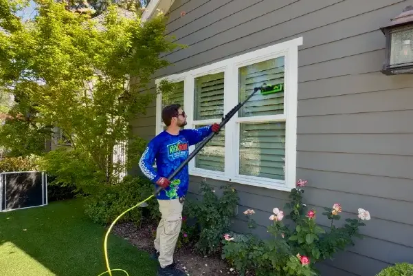 Rexterior cleaning a home's exterior windows with a water-fed pole in Pasadena