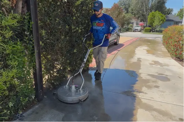 Rexterior pressure washing a concrete driveway with a surface cleaner in Pasadena