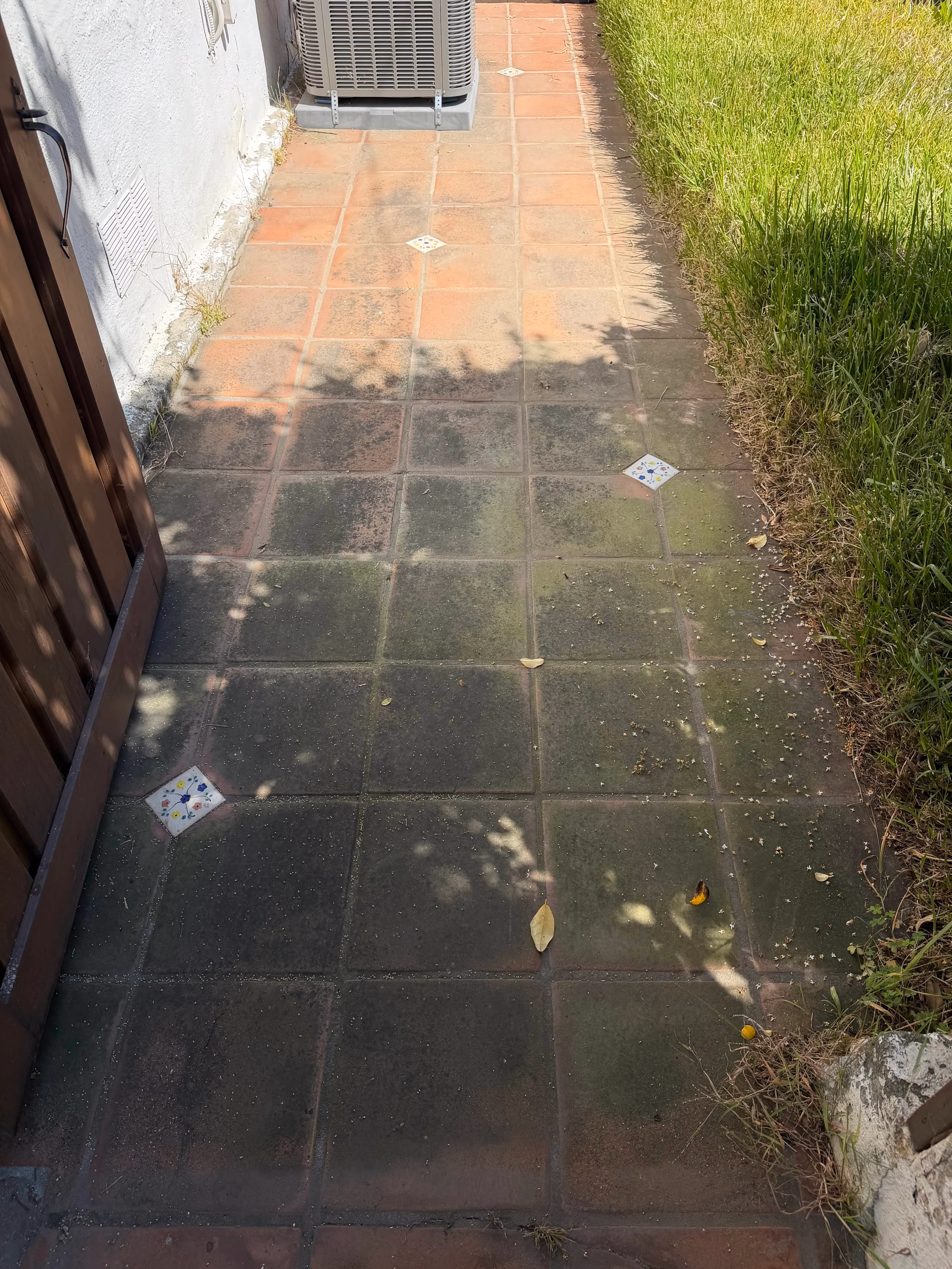 Dirty red brick paver patio before pressure washing in Pasadena