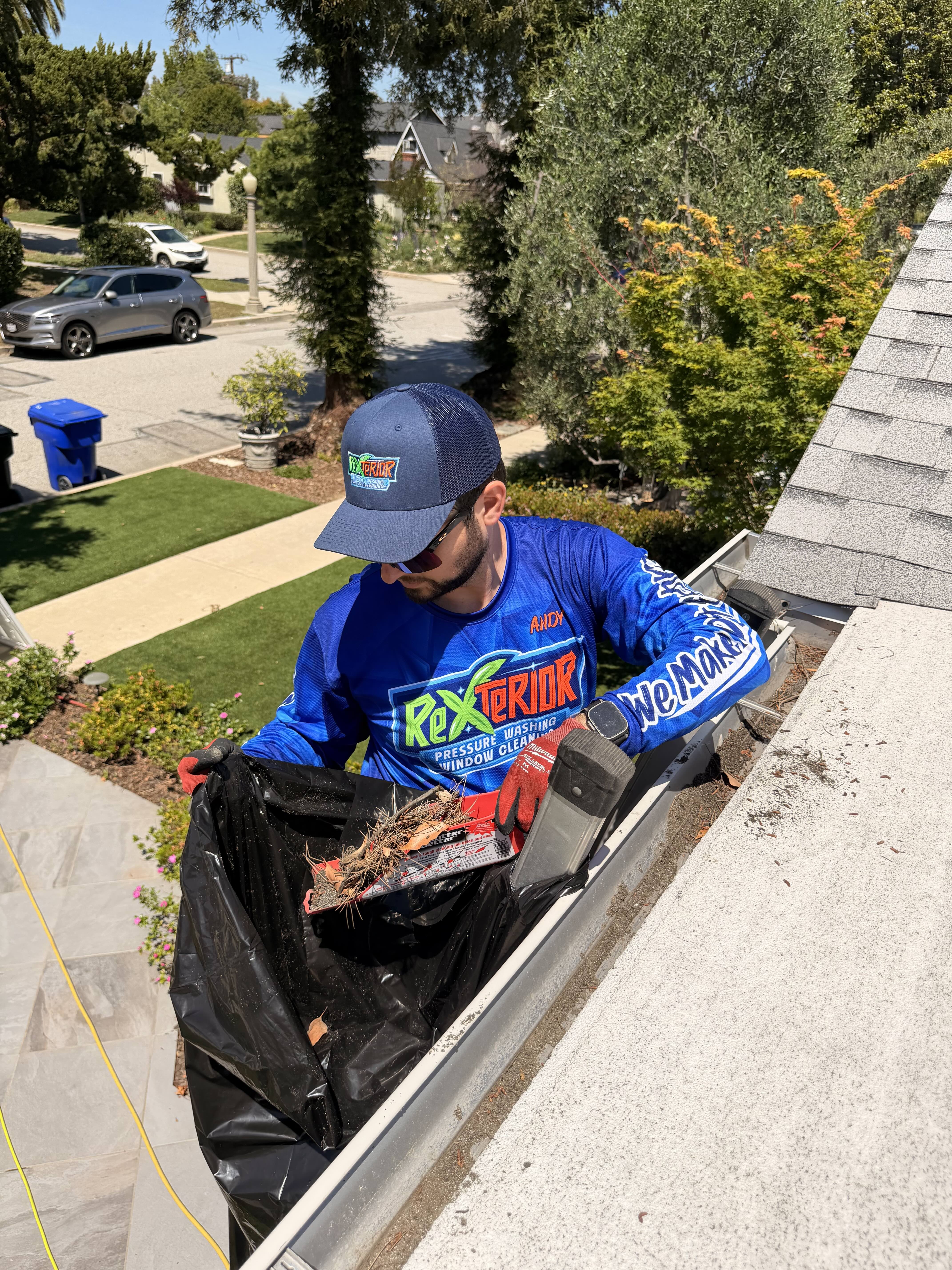 Rexterior technician removing debris from a residential gutter in Pasadena