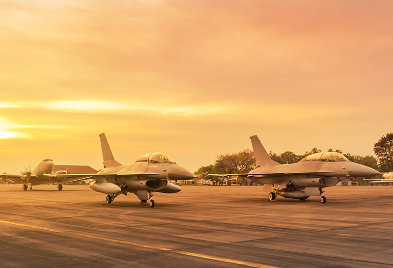 Military planes line an airstrip 