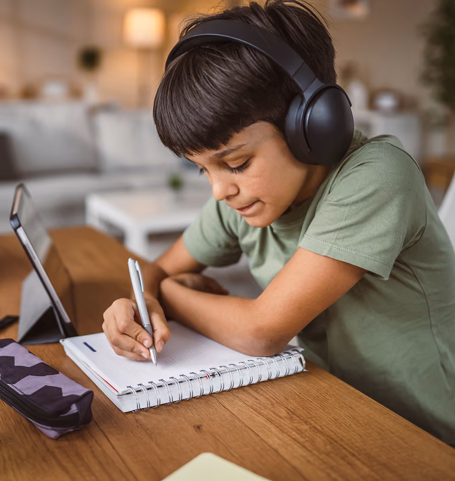A young boy wearing headphones while taking a school neuropsychological evaluation to assess memory and attention processing