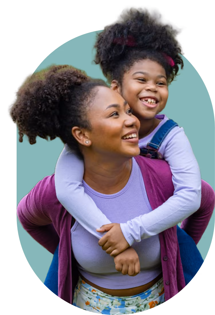 ): A happy mother giving her smiling daughter a piggyback ride after finding answers through a school neuropsychology assessment