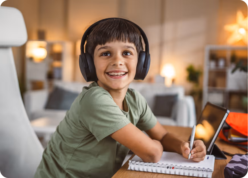 Boy wearing headphones doing schoolwork on a tablet during a psychoeducational assessment for ADHD, autism, and dyslexia