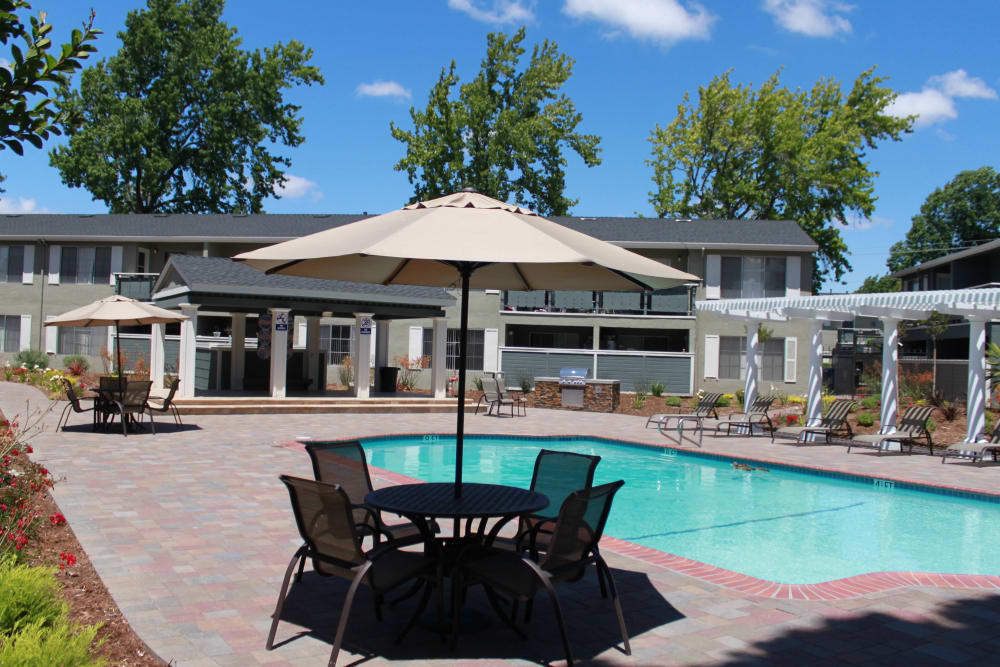 Swimming pool with table and chairs with umbrella