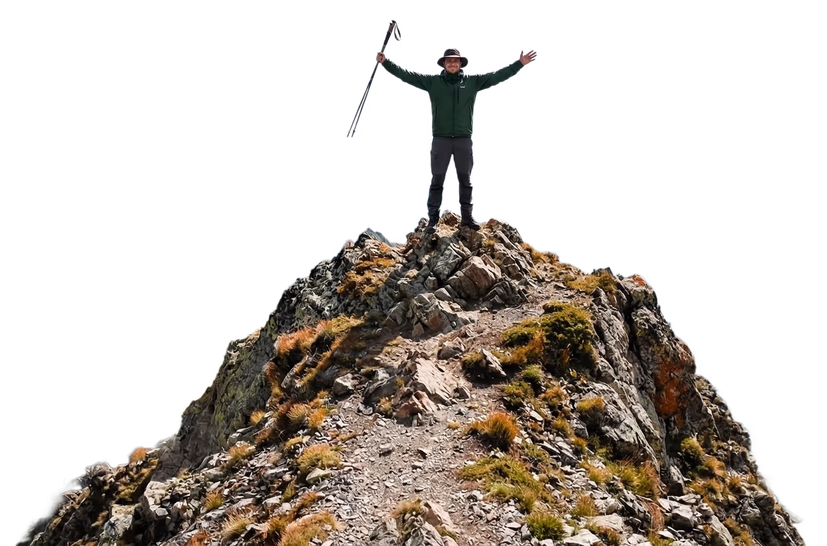 Hiker with trekking poles raised stands triumphantly atop a rocky mountain peak.
