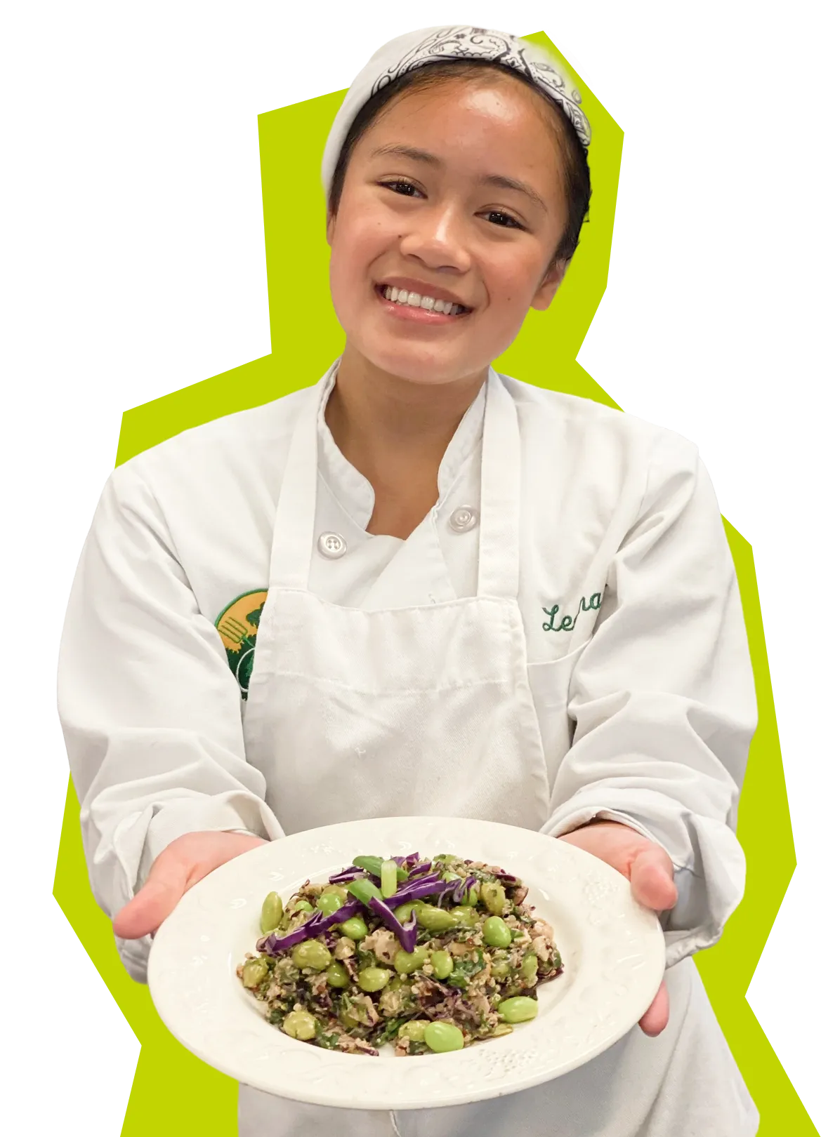 Smiling chef in white uniform holding a plate with a green bean and purple cabbage salad.