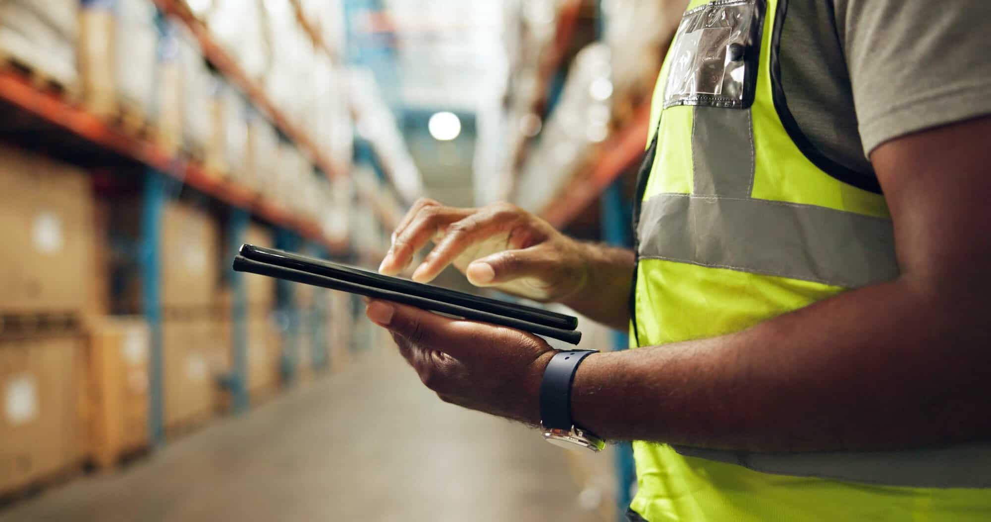 male with tablet in hand standing in a warehouse
