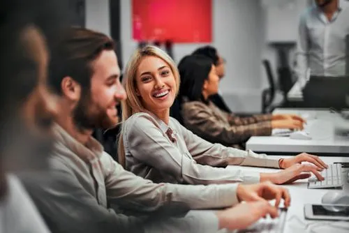 Blond, female IT professional smiling while working