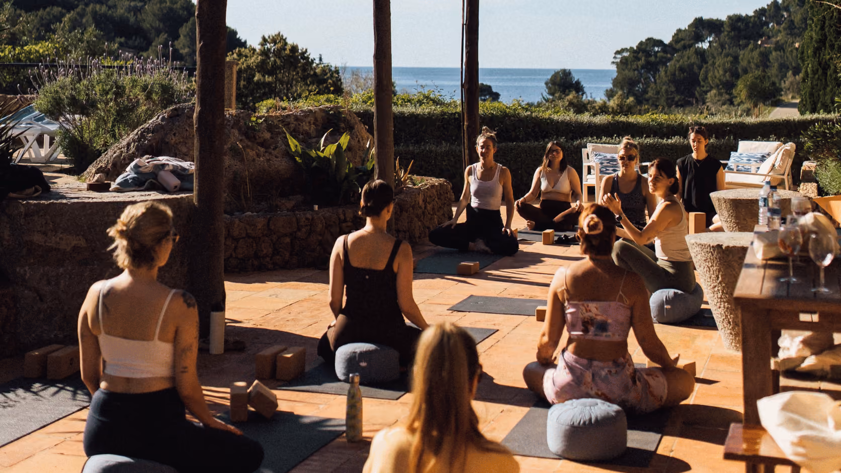 A group yoga session on a terrace overlooking the sea