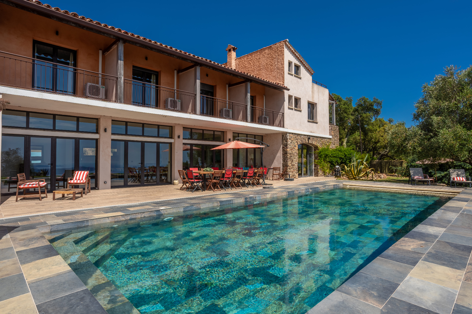 Aerial view of Castello Higos 15-metre swimming pool nestled among tall trees, vineyards, and the rolling Tuscan hills.