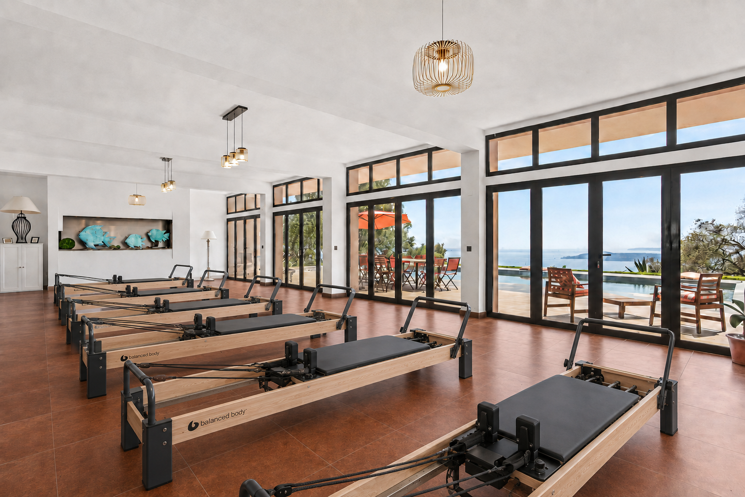 Open wooden doors in a fresco-covered yoga shala reveal a sunlit garden framed by leafy trees, with a yoga mat and blocks in the foreground